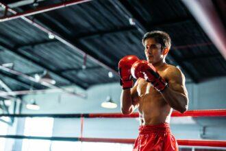 Asian professional sportsman doing boxing exercise in the boxing ring.