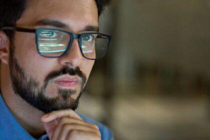 Business man wearing glasses with reflection using computer developing code.