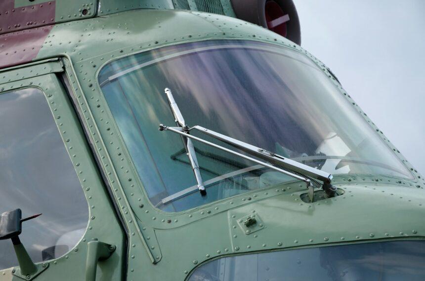 Helicopter cabin fragment close up. Camouflage aircraft fuselage