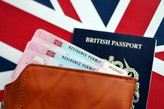 Residence Permit BRP card and British Passport of United Kingdom on Union Jack flag