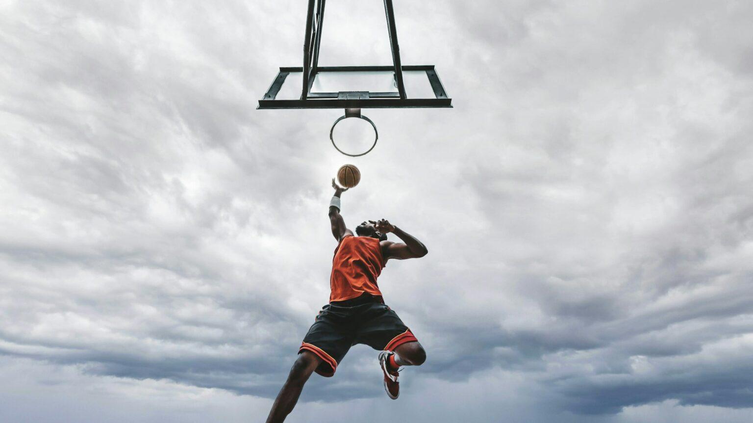 Street basketball player making a powerful slam dunk on the court