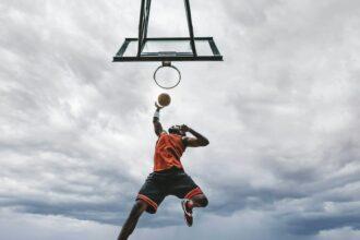 Street basketball player making a powerful slam dunk on the court