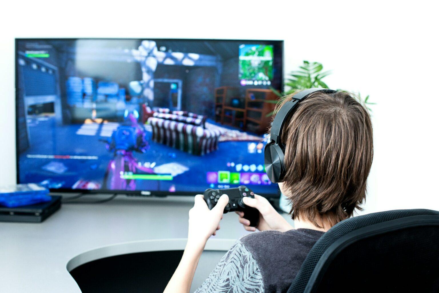 Teenager or young men play online video game. Gaming. Unrecognisable Gamer from back with joystick