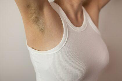 Unshaven armpits woman in white tank top