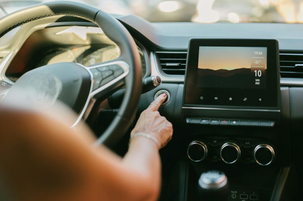 woman pressing the automatic start button on her car