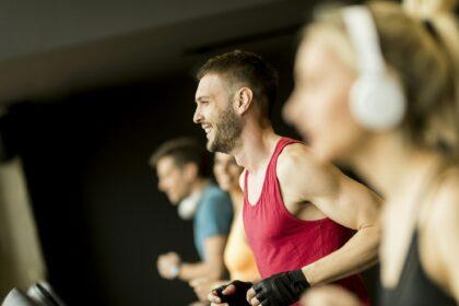 young people running on treadmills in modern gym