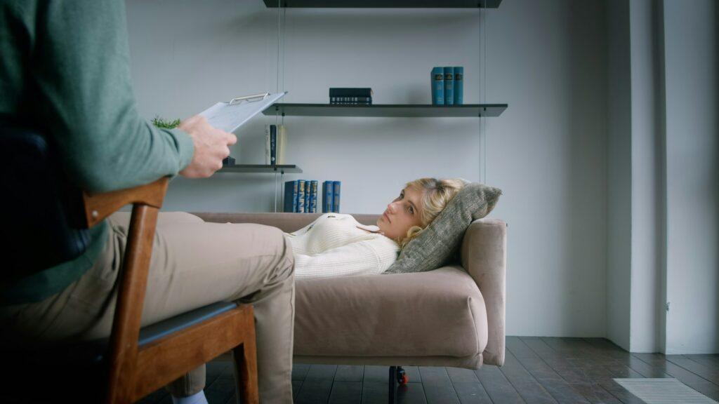 A psychotherapist conducting meditation for a patient on a couch