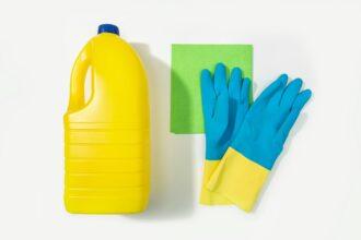 Bleach bottle, protective gloves and rag