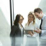 Businesspeople in office with woman using digital tablet