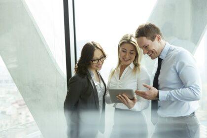 Businesspeople in office with woman using digital tablet