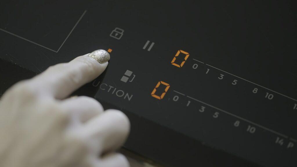 Close-up of turning on electric stove. Action. Turning on electronic plate panel. Panel with touch