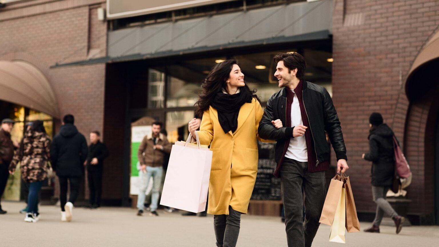 Consumerism concept. Couple shopping on weekend in mall