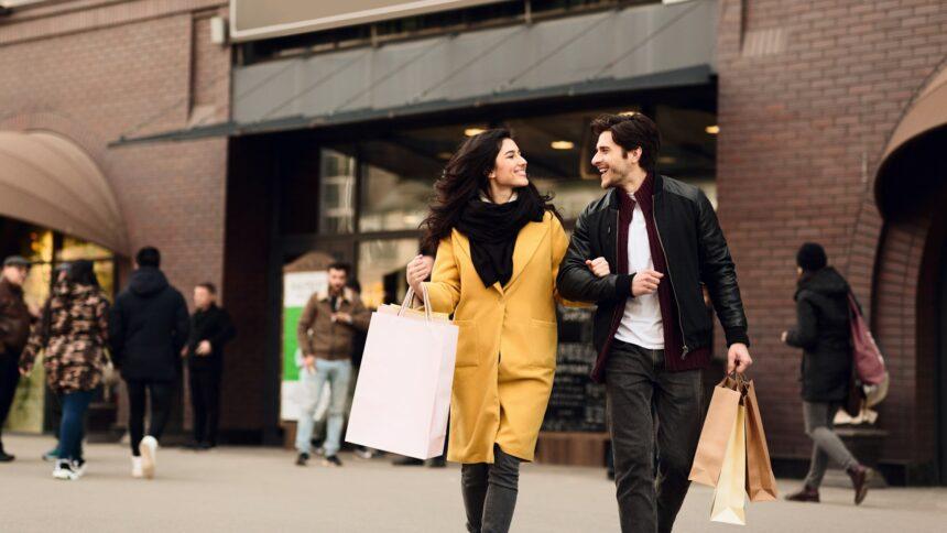 Consumerism concept. Couple shopping on weekend in mall