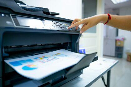 Office worker prints paper on multifunction laser printer. Copy, print, scan, and fax machine