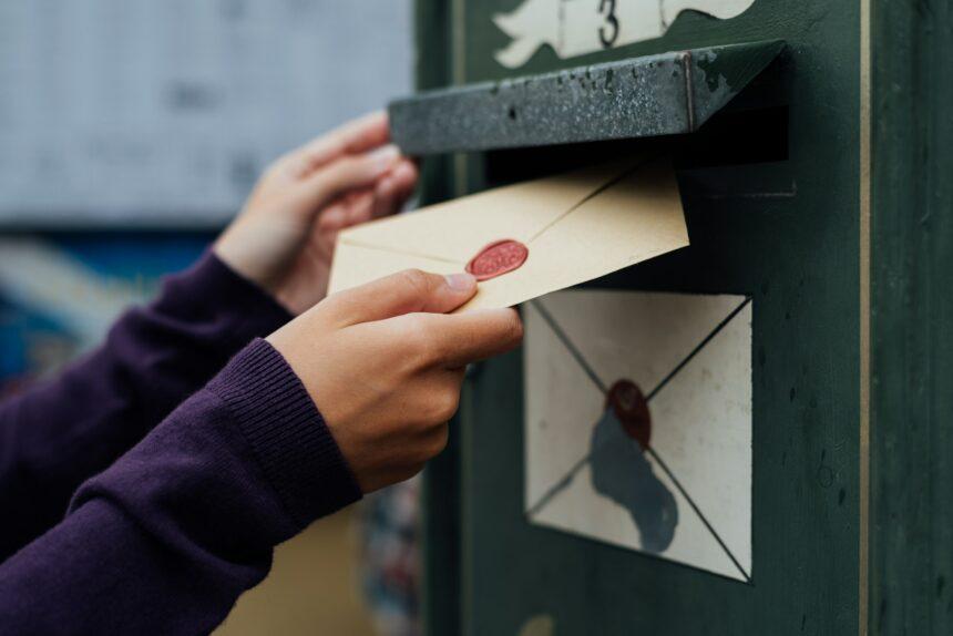 Posting letter to old postbox on street