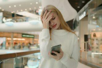 Sad Caucasian puzzled anxious female businesswoman 25s woman has problem with smartphone receive bad