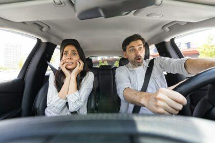 Shocked couple in automobile looking at road with shocked faces