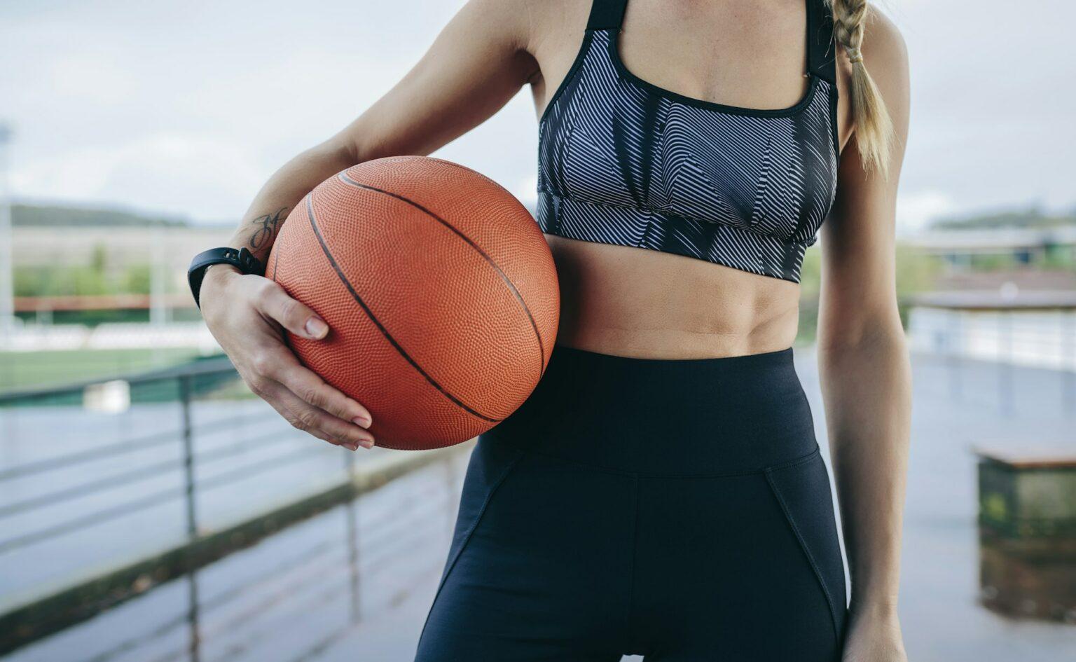 Sportswoman posing with a basketball