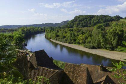 the river dordogne in september with green forest omn the mountains