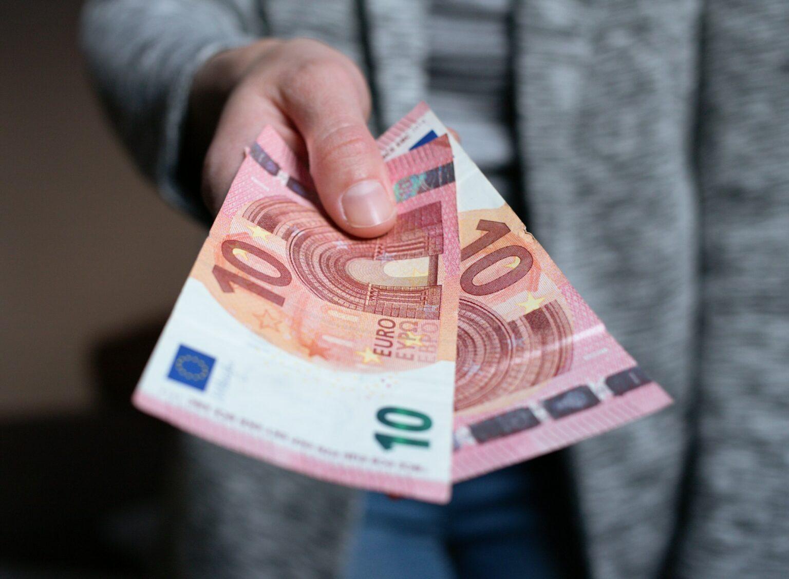 The woman gives the money. female hands hold and serve cash banknotes of 10 euro banknotes