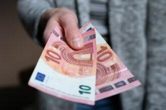 The woman gives the money. female hands hold and serve cash banknotes of 10 euro banknotes