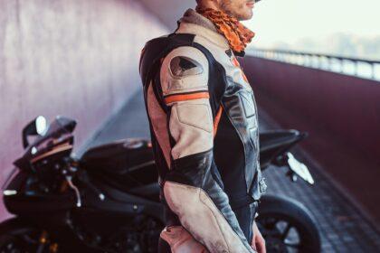 Young brave biker is standing near his motobike in quiet tunnel