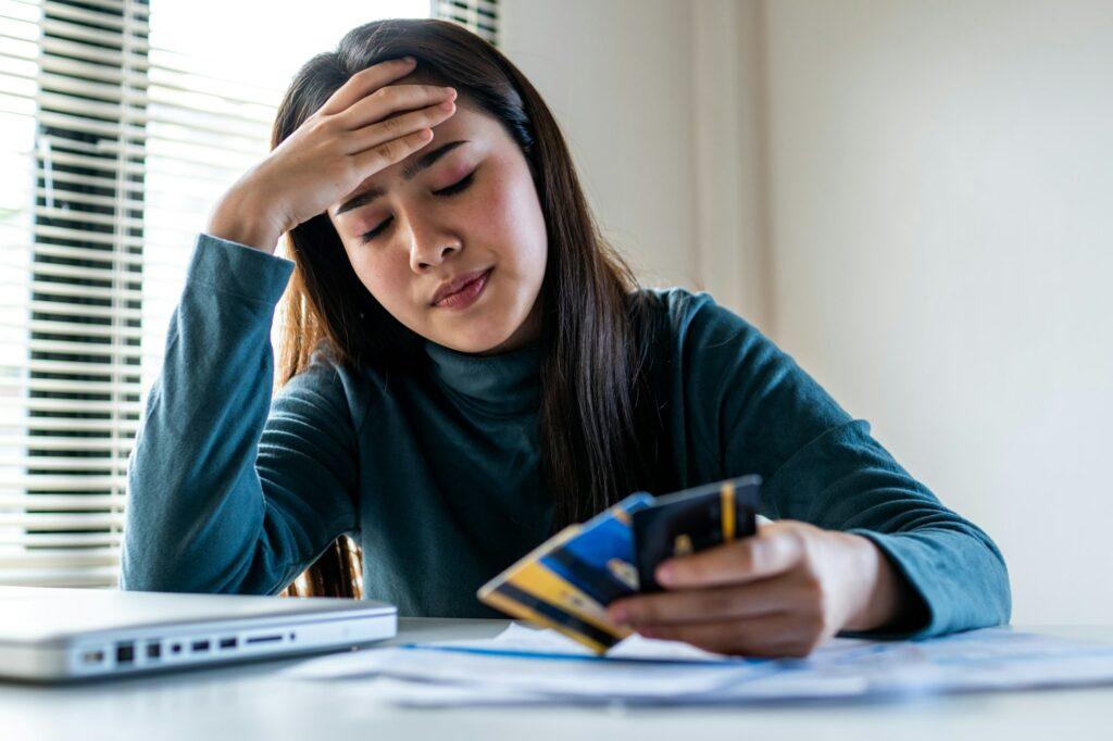 close up woman's hand holding three credit cards, feeling stressed about tax and debt problem