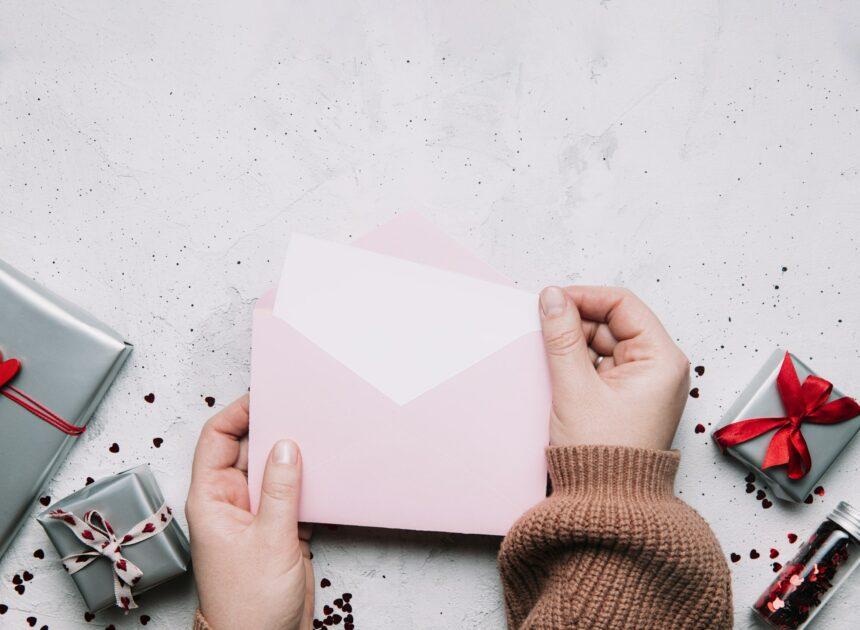 Female hands hold love letter message in envelope, Valentine's Day greeting card