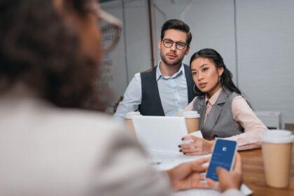 multiethnic businesspeople working together with tablet and smartphone with facebook appliance