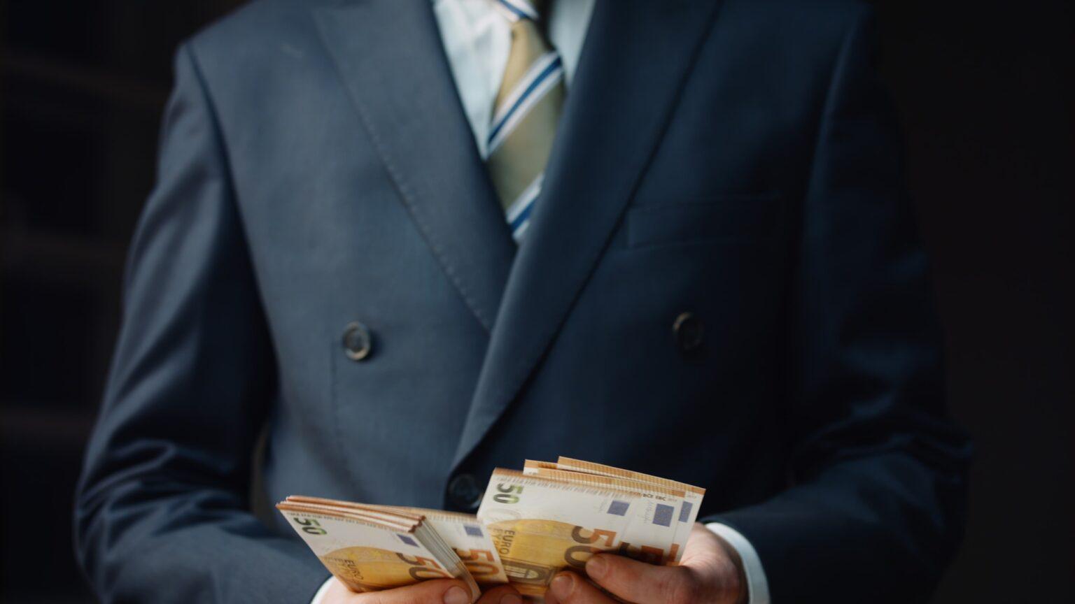 Successful financier counting salary in euro close up. Man calculating banknotes