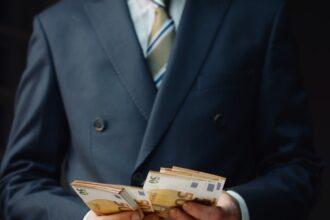 Successful financier counting salary in euro close up. Man calculating banknotes