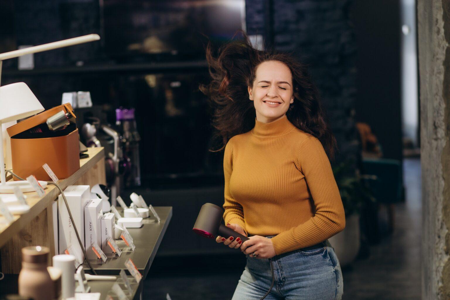 A woman buys a hair dryer in an electronics store