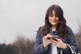 Closeup portrait young girl looking at phone messaging