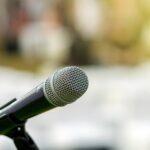 Microphone on the stage over the Abstract blurred photo of another music equipment