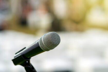 Microphone on the stage over the Abstract blurred photo of another music equipment