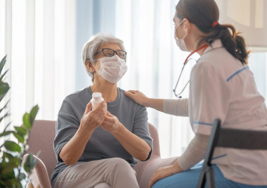 Doctor and senior woman wearing facemasks