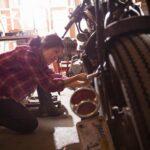 Female mechanic working on motorcycle in workshop