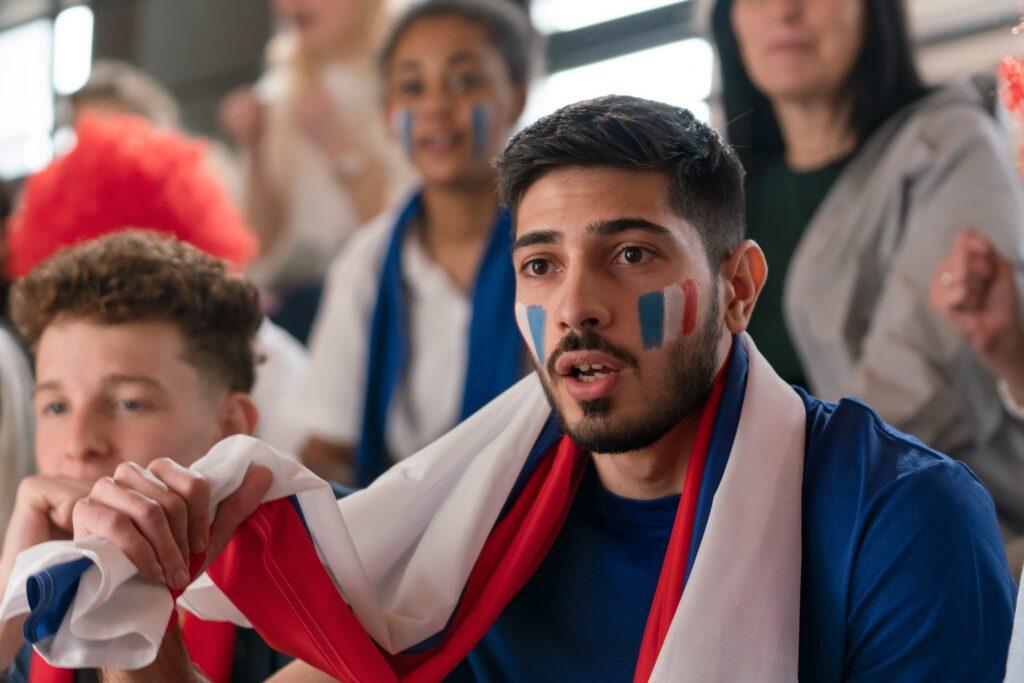 French football fans celebrating their team at stadium.