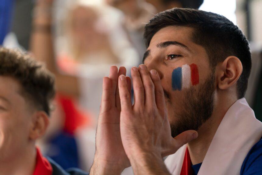 French football fans celebrating their team's victory at stadium.