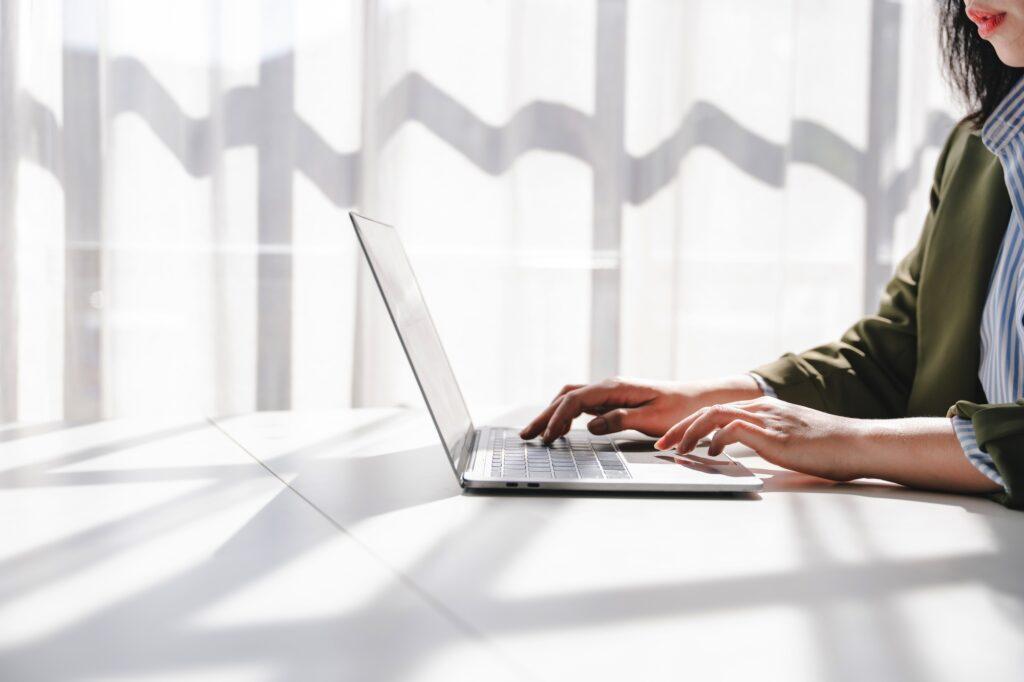 Typing on keyboard Working online on laptop computer On a white table at the office. Facebook chat.