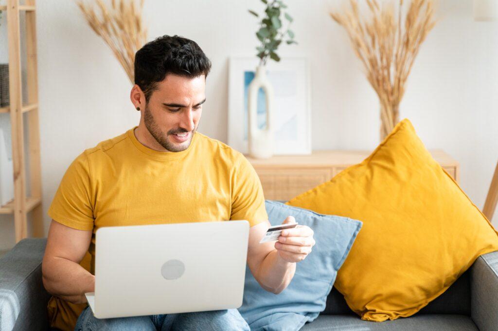 Young man with laptop checking his bank statement.