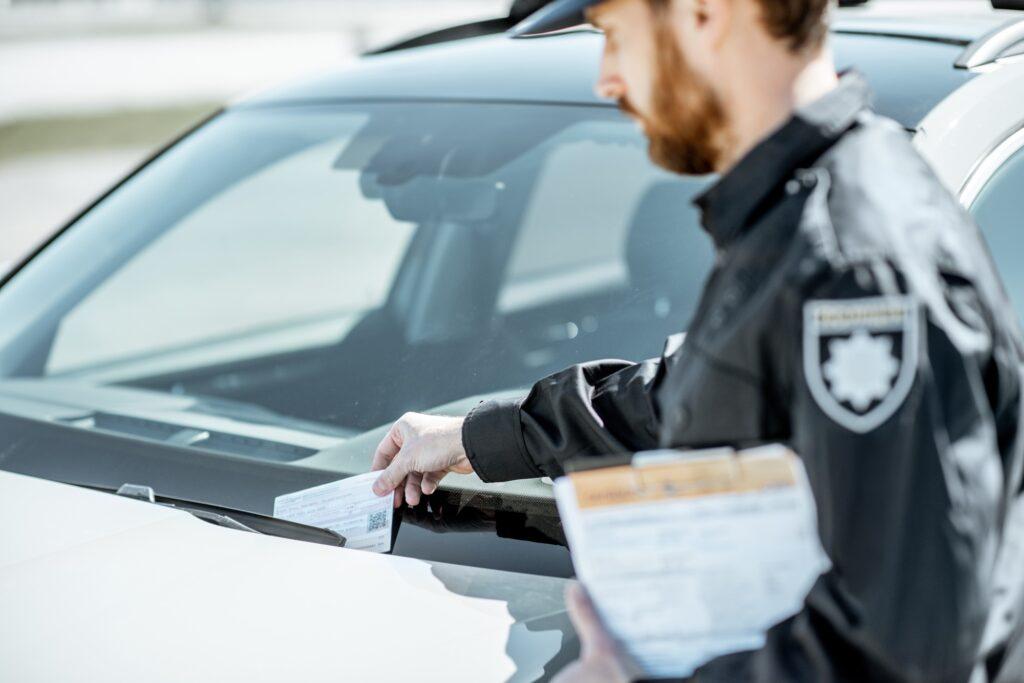 Policeman putting fine on the car