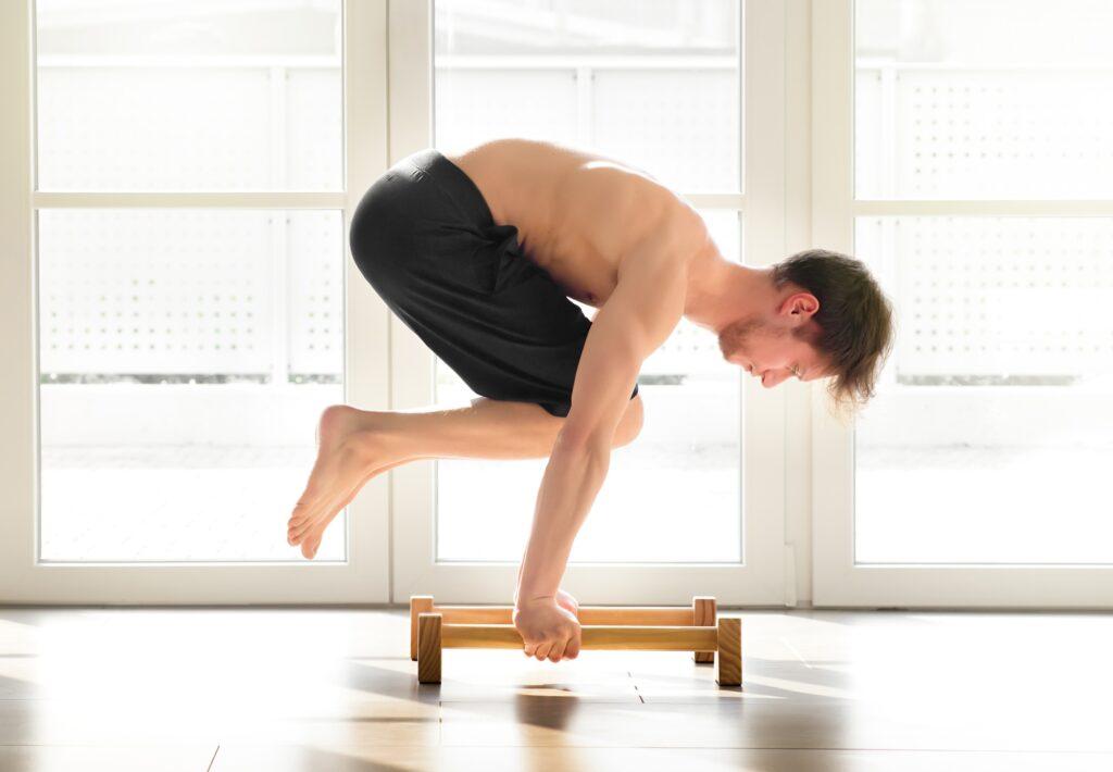 Young man doing a calisthenics crow pose