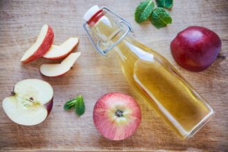 Natures detox. Overhead shot of a bottle of apple cider vinegar on a wooden table.