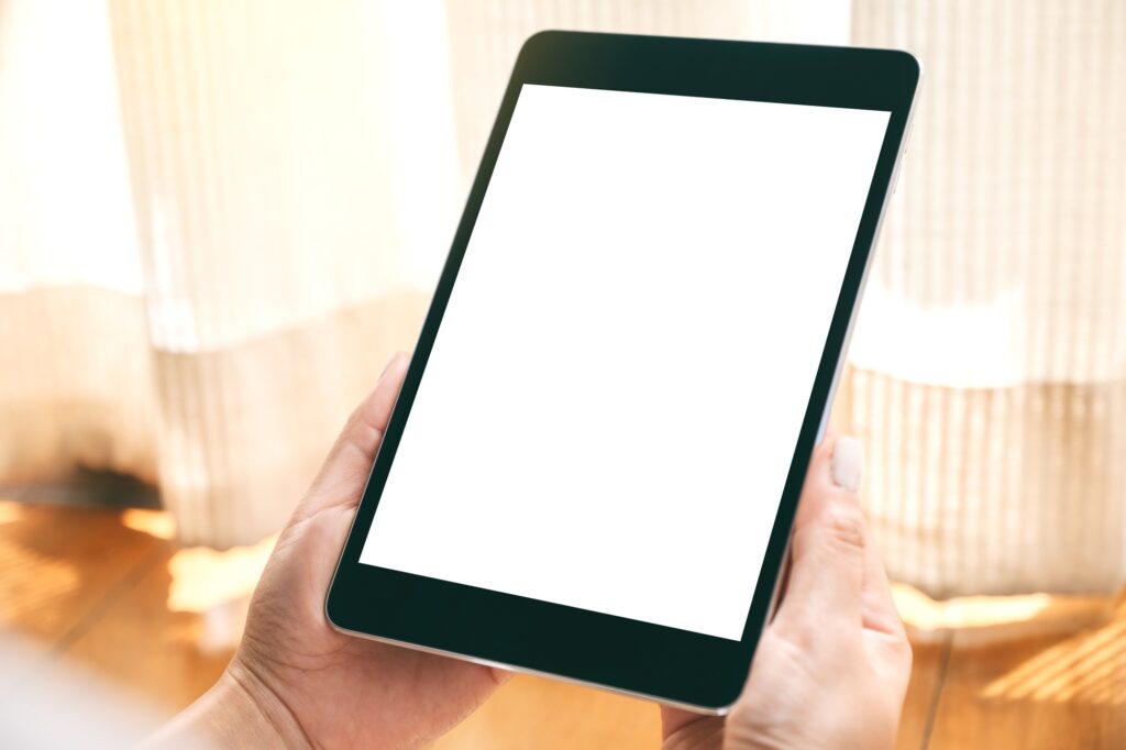 a woman holding black tablet pc with blank white desktop screen