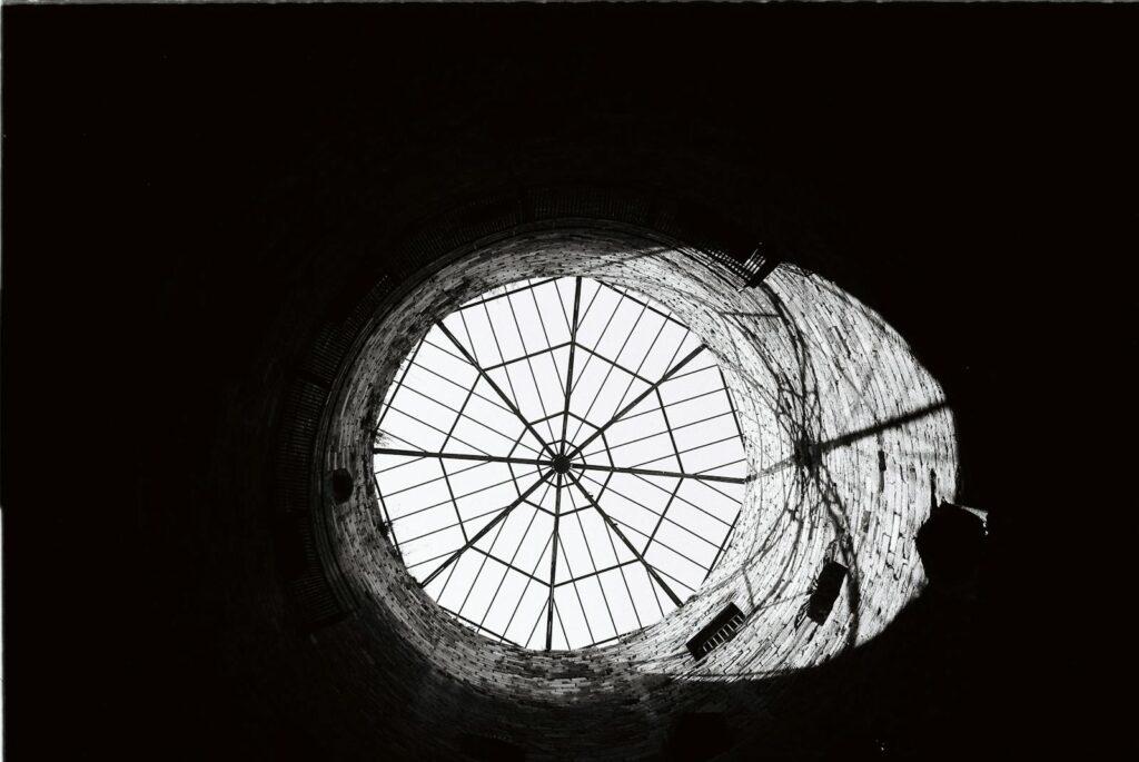 Striking black and white photograph of a dome with a geometric pattern taken indoors.