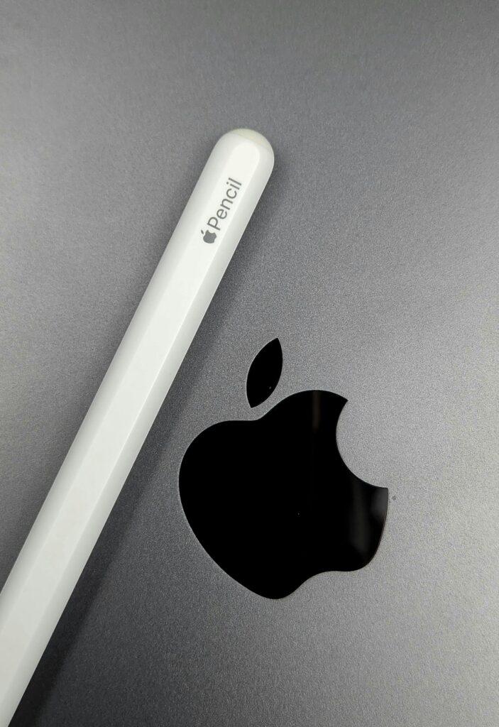 Minimalist shot of an Apple Pencil lying on a MacBook, showcasing sleek design.