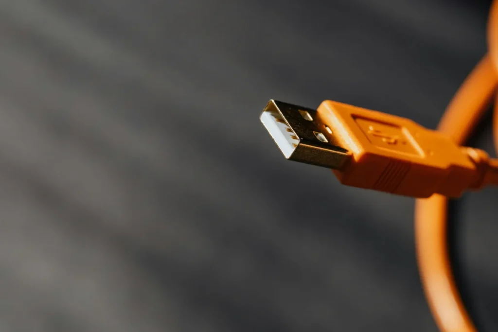 Detailed shot capturing an orange USB cable connector on a contrasting background.
