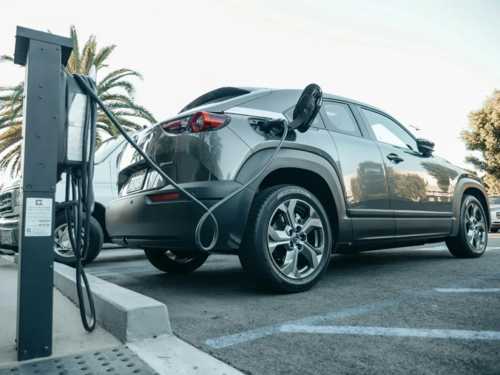 Ferrari, Volkswagen, Dacia : Découvrez les 20 modèles électriques les plus prometteurs qui arriveront en 2026 Modern electric vehicle charging at an outdoor station in daylight.