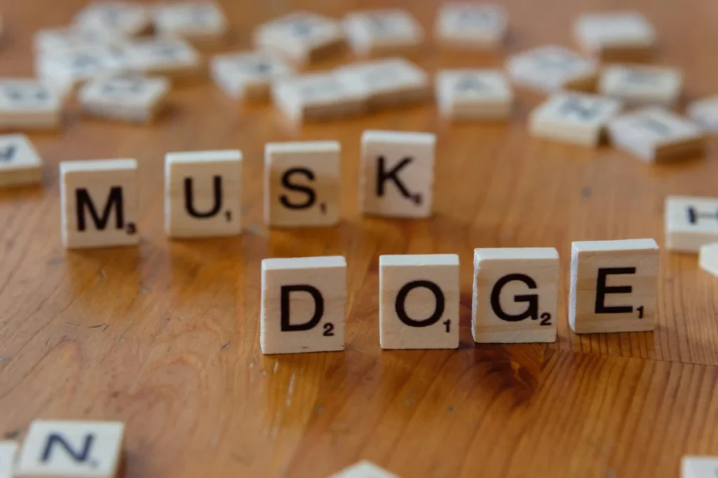 Scrabble tiles spelling 'DOGE' and 'MUSK' on a wooden table, highlighting internet culture and cryptocurrency.